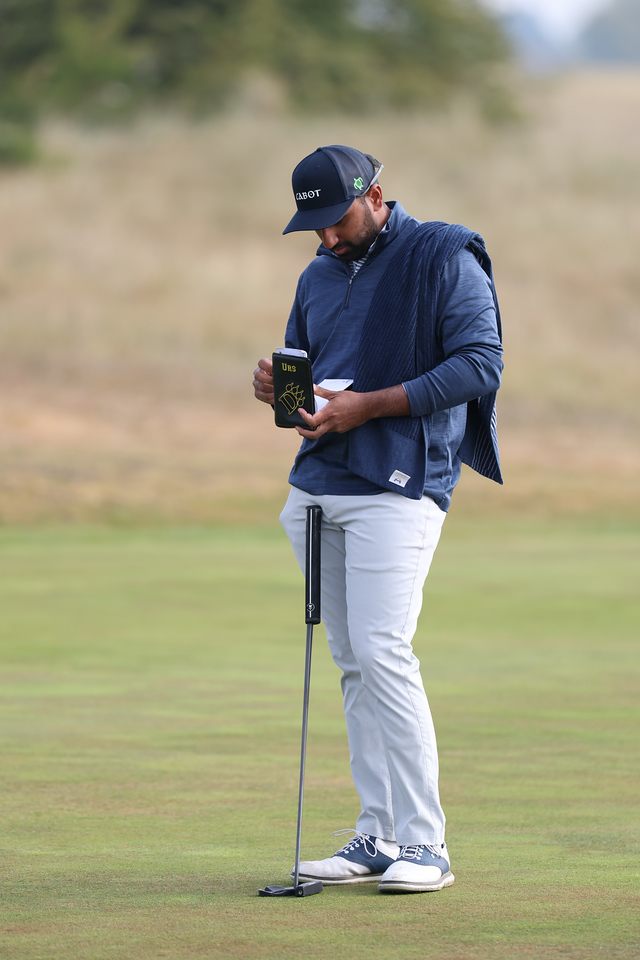 Yadhu Urs reading a yardage book on the course