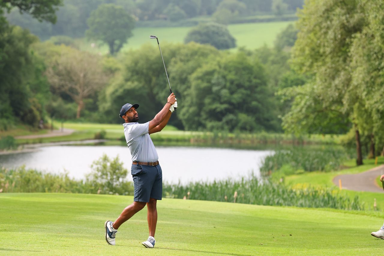 Yadhu Urs playing an approach shot on a parkland golf course