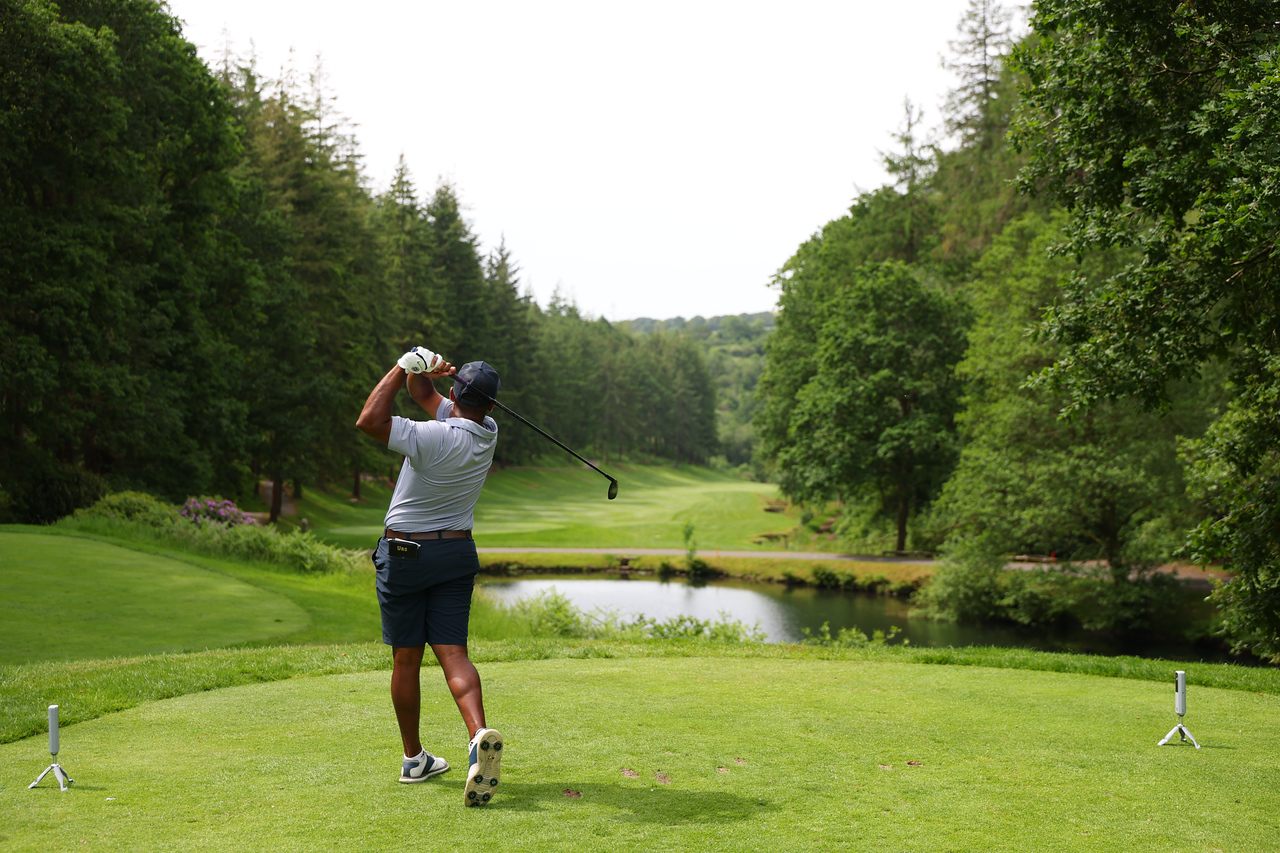 Yadhu Urs on the tee, playing down a tree-lined fairway